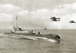 Hr.Ms. K 18 bij binnenkomst in Soerabaja, 1935. In de lucht vliegen drie Dornier Do J-Wal vliegboten (foto: collectie NIMH)